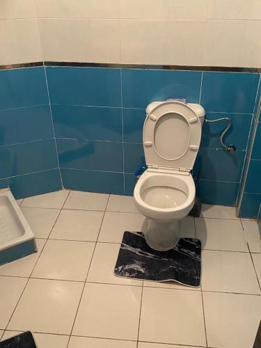 a bathroom with a toilet in a blue wall at Appartement Yasmine à Martil in Martil