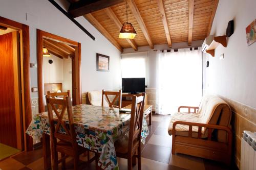 a dining room with a table and chairs and a television at Apartamentos Hervasypunto in Hervás