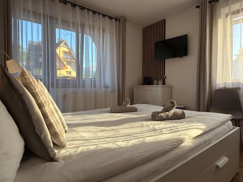 a large white bed in a room with a window at Rodzinna Ostoja in Zakopane