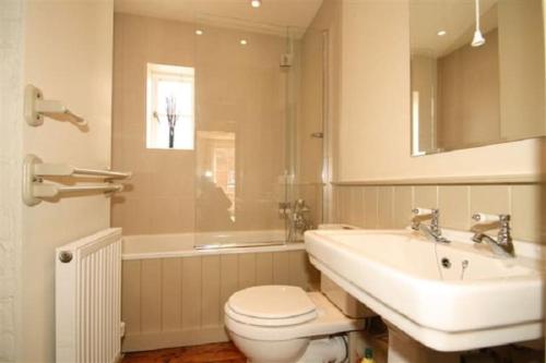 a bathroom with a sink and a toilet and a tub at Gorgeous House by City Walls in Canterbury