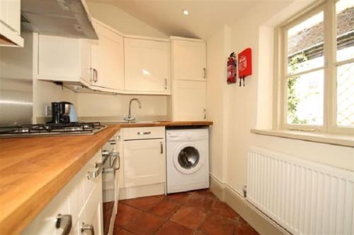 a kitchen with a washing machine and a window at Gorgeous House by City Walls in Canterbury