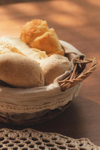 a basket filled with bread and rolls on a table at Pousada Casa Mandacaru Noronha in Fernando de Noronha