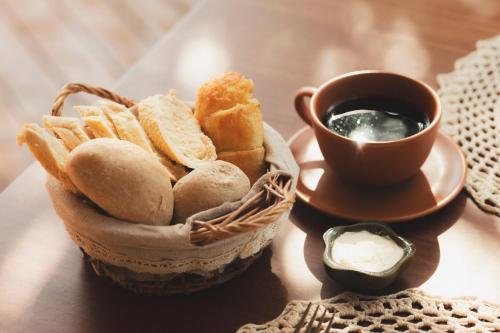 a basket of bread and a cup of coffee on a table at Pousada Casa Mandacaru Noronha in Fernando de Noronha