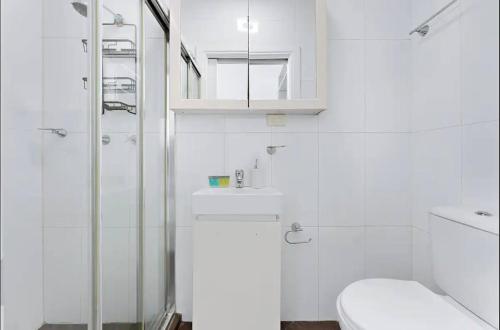 a white bathroom with a shower and a toilet at Fantastic stay-walk to darling harbour&fish market in Sydney