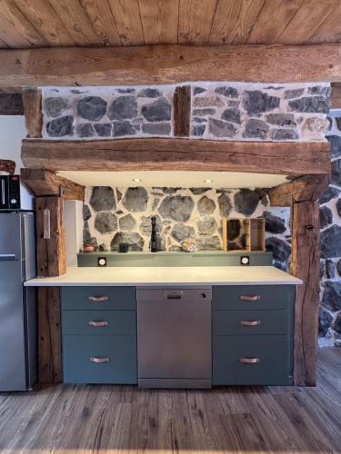 a kitchen with a stone wall at Maison Ombre du Clocher in Laguiole