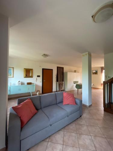 a living room with a blue couch with two red pillows at Verdemare Apartments in Fano