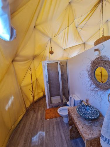 a bathroom with a toilet in a tent at Timlalin Dome in Tamri