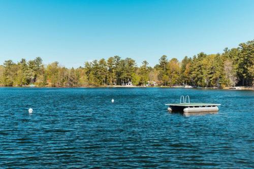 a small boat in the middle of a lake at TC Lake Stay-Pontoon & SUP Rentals - Sleeps 4! in Traverse City