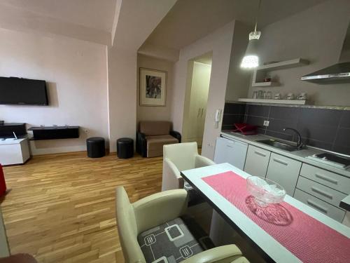 Una cocina y una sala de estar con mesa y sillas. en Baron Ohrid Makedonija, en Ohrid