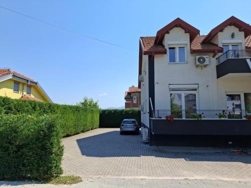 a house with a car parked in a driveway at VilaMihaela in Skopje