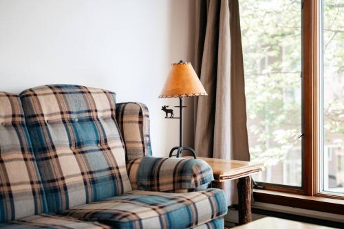a living room with a chair and a lamp and a table at TC Lake Stay-Pontoon & SUP Rentals - Sleeps 4! in Traverse City
