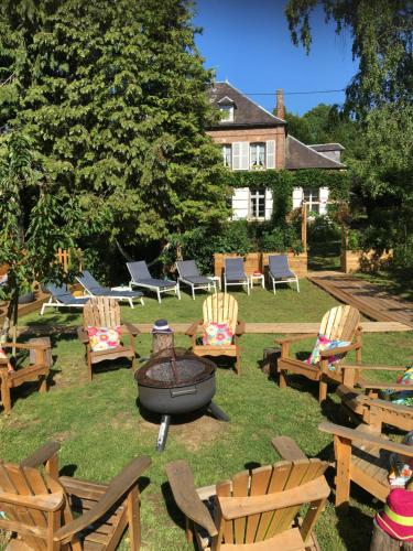 a group of chairs and a fire pit in a yard at Villa des glycines et Spa in Cempuis