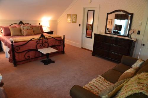 a bedroom with a bed and a dresser and a mirror at Victoria Inn in Hampton