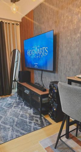 a living room with a flat screen tv on a wall at SW Staycation Sam Suite SMDC Hope Residences Beside SM City in Trece Martires