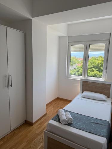 una camera da letto con un letto e due finestre di Astor Apartment a Gevgelija