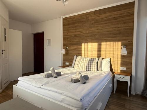 a bedroom with a large white bed with a wooden headboard at Rodzinna Ostoja in Zakopane