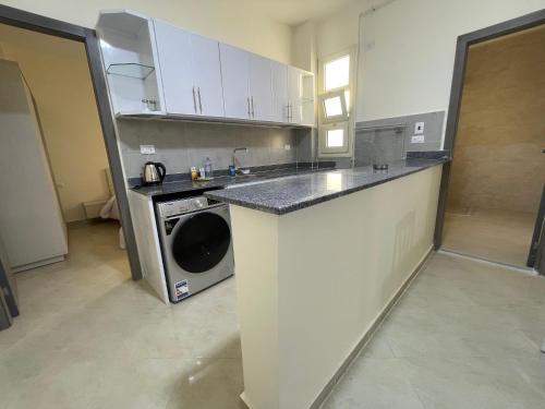 a kitchen with a sink and a washing machine at Bayt Hassan A13 - Superb 2 bedrooms in Hurghada