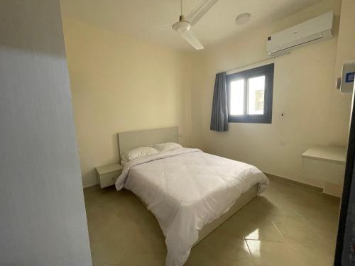 a bedroom with a white bed and a window at Bayt Hassan A13 - Superb 2 bedrooms in Hurghada