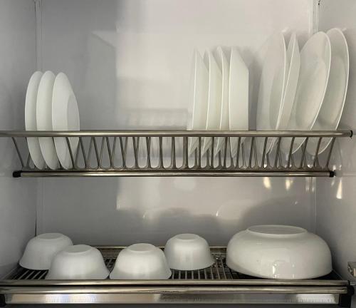 a shelf with white plates and bowls in a kitchen at Bayt Hassan A13 - Superb 2 bedrooms in Hurghada