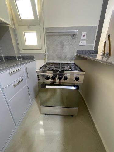 a kitchen with a stove top oven in a kitchen at Bayt Hassan A13 - Superb 2 bedrooms in Hurghada