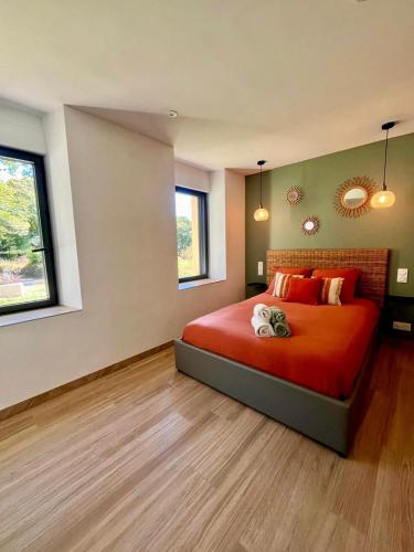 - une chambre avec un lit doté de draps rouges et 2 fenêtres dans l'établissement Maison bretonne rénovée à 20 min des plages, parking privé, à Grand-Champ