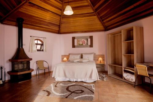 a bedroom with a bed and a fireplace at Pousada Villa Da Montanha in São Bento do Sapucaí