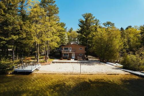 an aerial view of a house in the woods at TC Lake Stay-Pontoon & SUP Rentals - Sleeps 4! in Traverse City