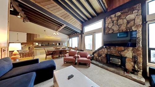 a living room with a large stone wall with a fireplace at Cozy 4-Bedroom Home with Pool and Mountain View! in Mammoth Lakes