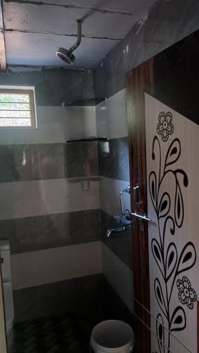 a bathroom with a shower with a toilet in it at Saketa Homestay in Linganamakki
