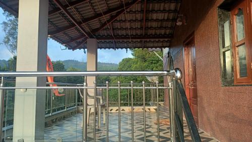 a balcony with a gate and a view of a yard at Saketa Homestay in Linganamakki