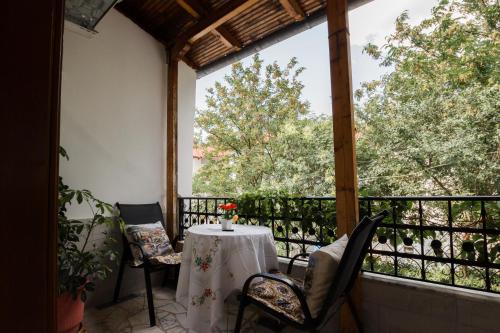 a table and chairs on a balcony with trees at Kashah Residence in Gjirokastër