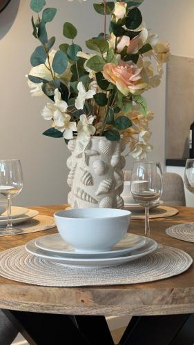 a table with a white vase with flowers in it at De Kajuit in Westkapelle