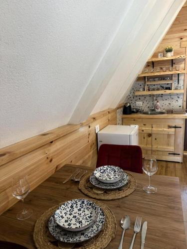 a dining room table with two plates and wine glasses at Vekova koliba in Žabljak