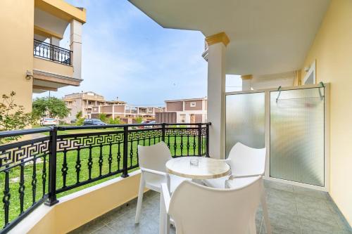 a balcony with a table and chairs and a view at Kosmos Hotel in Agios Stefanos