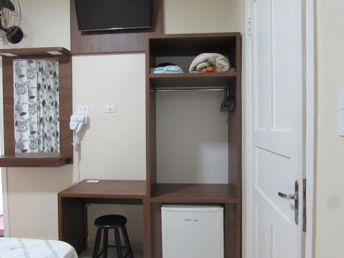 a room with a small desk and a shelf at Las Vegas Hotel in Sao Paulo