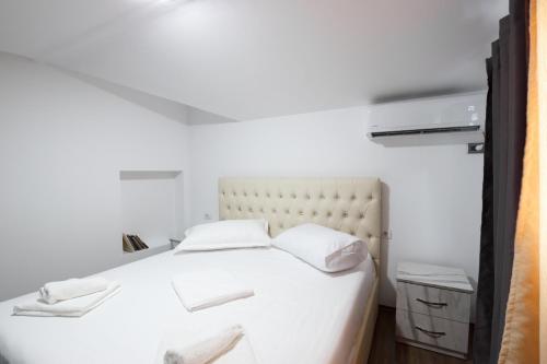 a white bed with two white towels on it at Kashah Residence in Gjirokastër