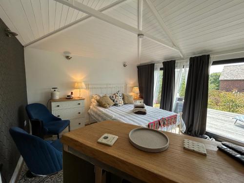 a bedroom with a bed and a desk with a table at Stylish Cabin in East Sussex near Newhaven ferry in Newhaven