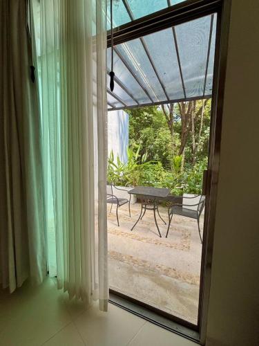 an open door to a patio with a table outside at Hotel Nututun Palenque in Palenque