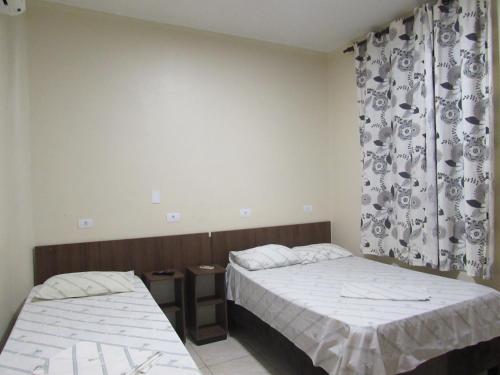 a bedroom with two beds and a curtain at Las Vegas Hotel in Sao Paulo