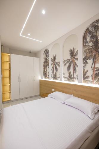 a bedroom with a large bed with palm trees on the wall at Nova Studio Drymades in Dhërmi
