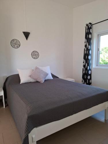 1 dormitorio con 1 cama con edredón negro y ventana en Sun Tonic, en Tamarin