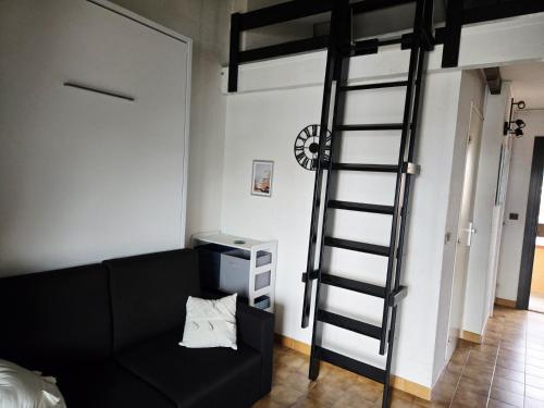 - un salon avec un canapé noir et une mezzanine dans l'établissement Appartement cosy avec vue sur la Marina - Résidence parking privé, à Saint-Cyprien