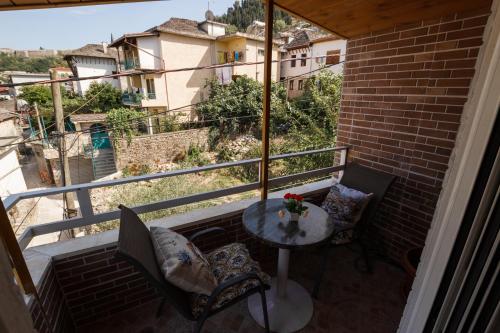 a balcony with a table and chairs and a view at Kashah Residence in Gjirokastër