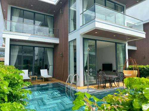 a house with a swimming pool in the yard at Greenlife Village Phú Quốc in Phu Quoc