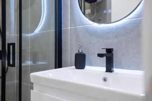 a bathroom with a sink with a soap bottle on it at Nova Studio Drymades in Dhërmi