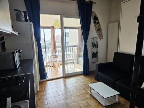 d'un salon avec un canapé et un balcon. dans l'établissement Appartement cosy avec vue sur la Marina - Résidence parking privé, à Saint-Cyprien