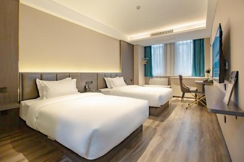 a hotel room with two beds and a desk at Star Hotel in Baoding