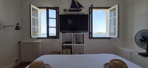 a bedroom with a bed and a flat screen tv at La maison bleue in Bouzigues