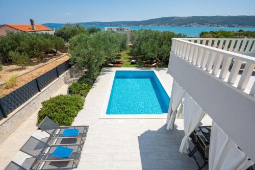 a view of a swimming pool from the balcony of a house at Beachfront villa Mihovil with direct beach access in Kastel Stafilic