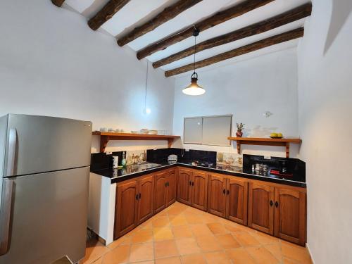 een keuken met houten kasten en een roestvrijstalen koelkast bij Apartamento de la Villa II in Villa de Leyva